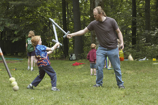 Adult and child in play sword fight