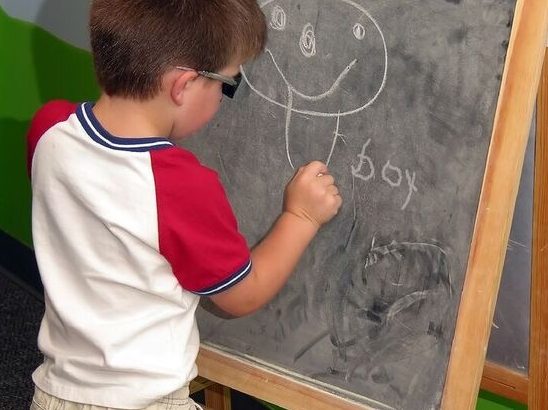 Child at blackboard doing spelling task