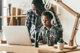 adult assisting child at computer with speech-to-text