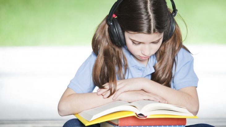 Dyslexia Instruction: Girl listening to book while tracking along