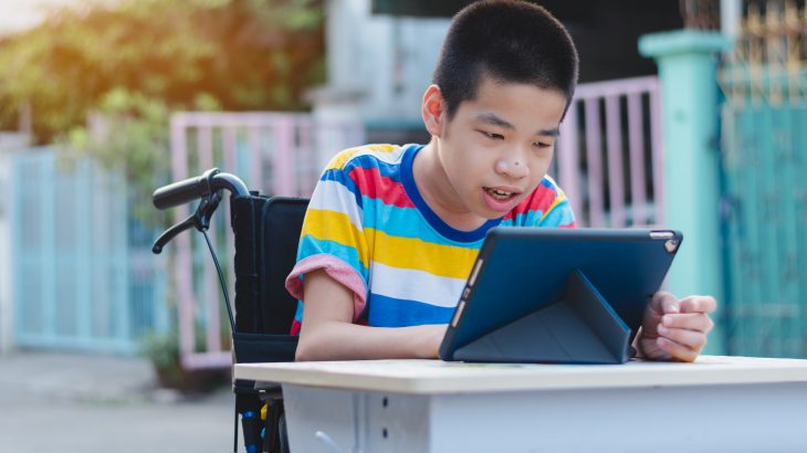 boy in wheelchair tracking reading on ipad