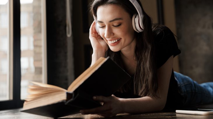 high school student using headphones to do audio-assisted reading